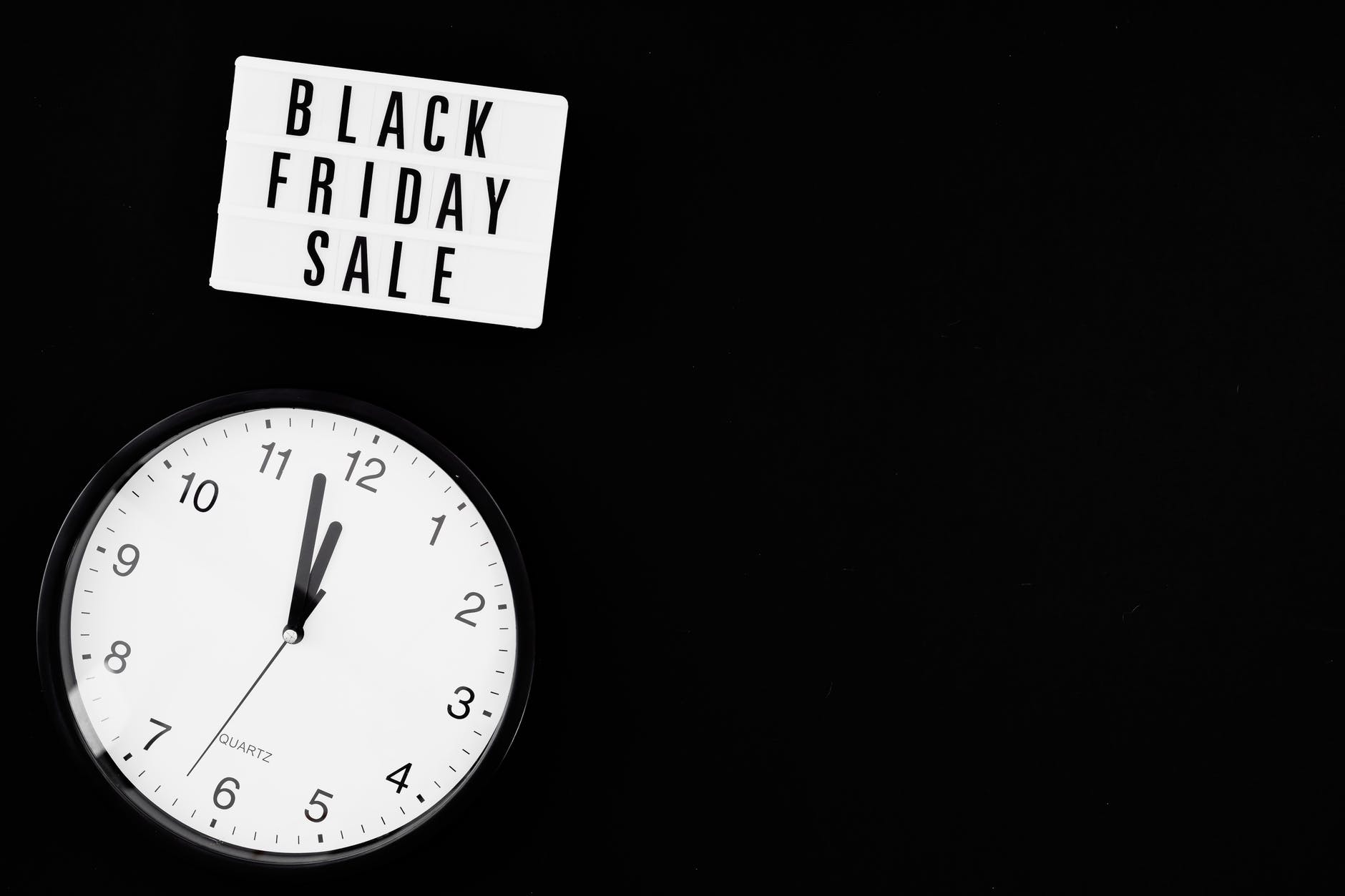 black and white analog wall clock showing time of black friday sale